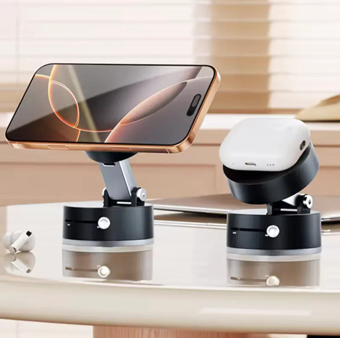 Smartphone and earbud case on sleek black stands, modern desk setup