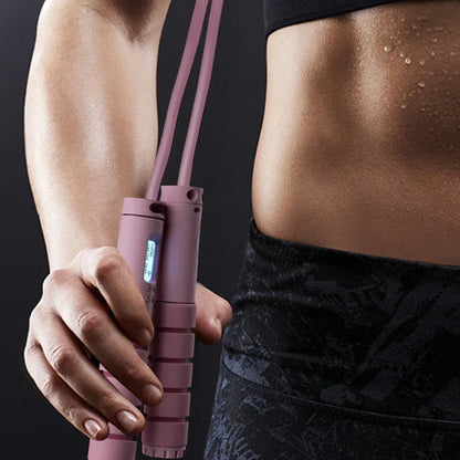 Pink smart jump rope with digital counter held by fit woman in workout gear