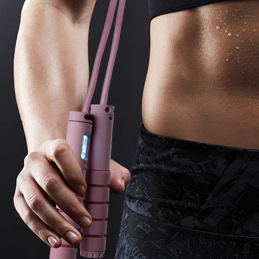 Pink smart jump rope with digital counter held by fit woman in workout gear